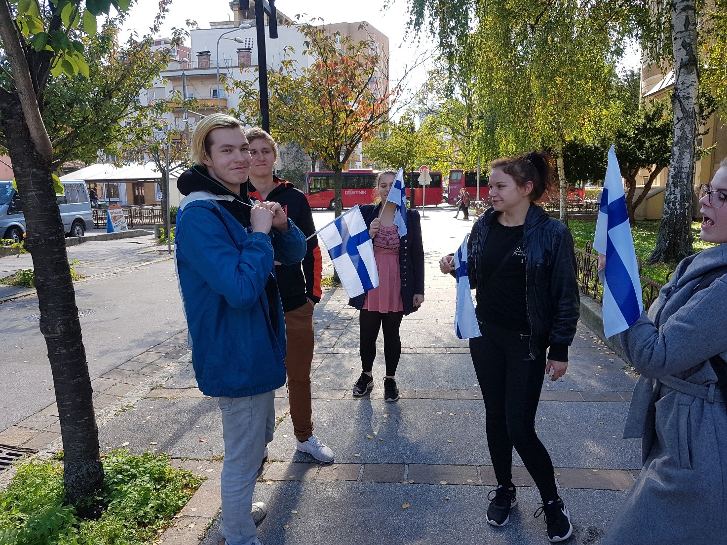 opiskelijoita pienet suomen liput käsissään ulkomailla
