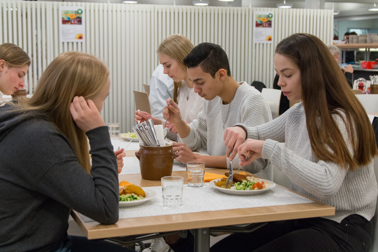 opsikelijat syömässä koulun ruokalassa